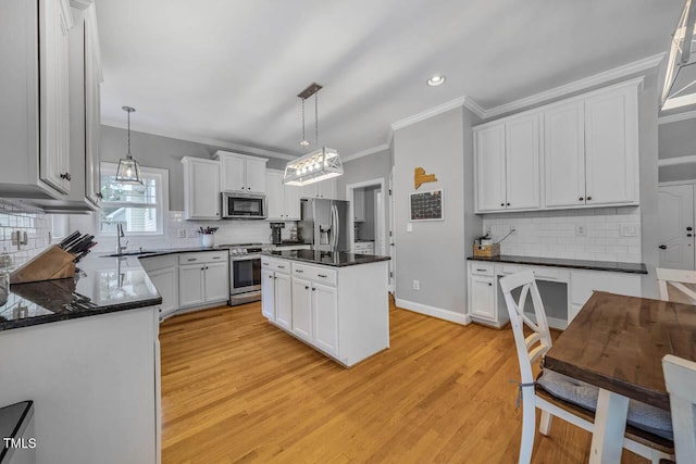 7269 Bedford Ridge Dr, Apex, NC 27539 - kitchen with stainless steel appliances, crown molding, decorative backsplash, dark countertops, and light wood-style floors