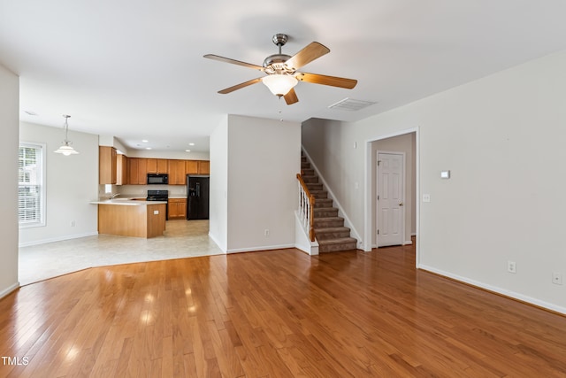 2228 Cedar Grove Dr, Durham, NC 27703 - unfurnished living room with stairs, light wood-style floors, a ceiling fan, and recessed lighting