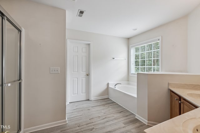 2228 Cedar Grove Dr, Durham, NC 27703 - bathroom with vanity, a garden tub, wood finished floors, and a stall shower