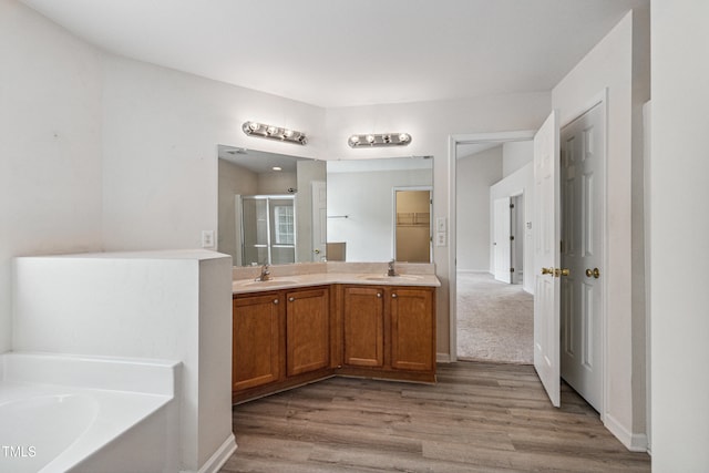 2228 Cedar Grove Dr, Durham, NC 27703 - full bathroom featuring a shower stall, wood finished floors, a bath, and double vanity