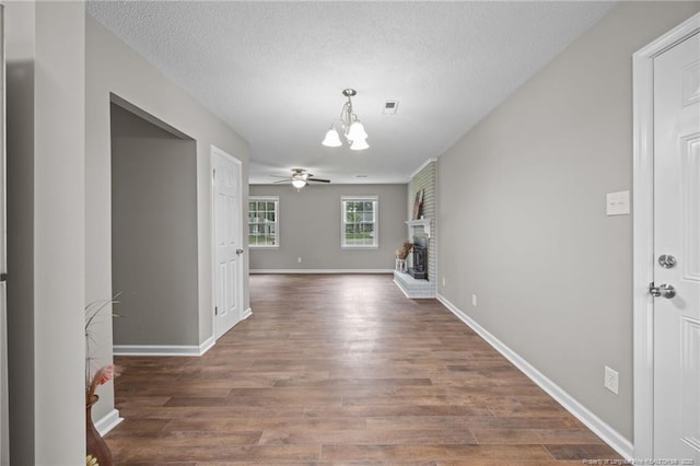 615 Wallingford Ct, Fayetteville, NC 28314 - unfurnished living room with a chandelier, wood finished floors, a ceiling fan, a textured ceiling, and a brick fireplace