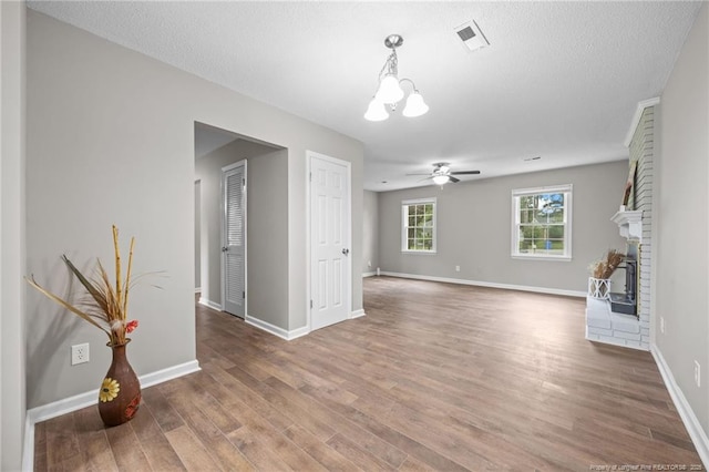 615 Wallingford Ct, Fayetteville, NC 28314 - unfurnished living room with wood finished floors, a chandelier, a ceiling fan, and a brick fireplace