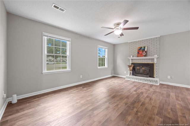 615 Wallingford Ct, Fayetteville, NC 28314 - unfurnished living room featuring ceiling fan, wood finished floors, a brick fireplace, and a textured ceiling
