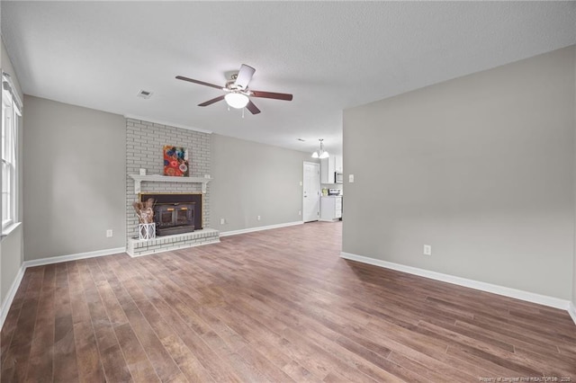 615 Wallingford Ct, Fayetteville, NC 28314 - unfurnished living room featuring ceiling fan, wood finished floors, and a brick fireplace