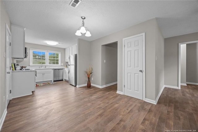 615 Wallingford Ct, Fayetteville, NC 28314 - kitchen with appliances with stainless steel finishes, dark wood finished floors, light countertops, white cabinets, and a textured ceiling