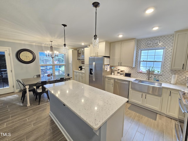 4411 Fairland Ct, Burlington, NC 27215 - kitchen featuring stainless steel appliances, a chandelier, light wood-style flooring, a kitchen island, and backsplash