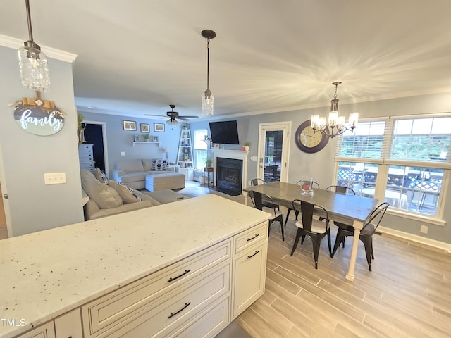 4411 Fairland Ct, Burlington, NC 27215 - kitchen with a fireplace with flush hearth, a chandelier, crown molding, ceiling fan, and light stone counters