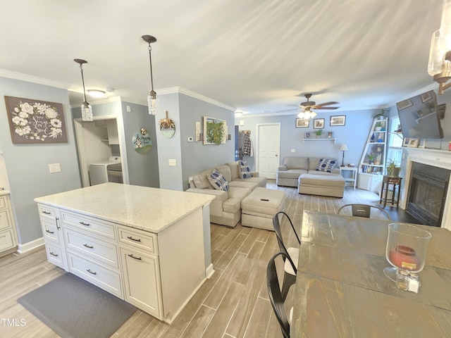 4411 Fairland Ct, Burlington, NC 27215 - kitchen featuring light wood finished floors, ceiling fan, a fireplace, crown molding, and hanging light fixtures