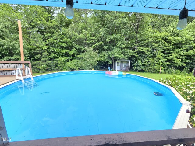 4411 Fairland Ct, Burlington, NC 27215 - swimming pool featuring an outdoor structure and a view of trees