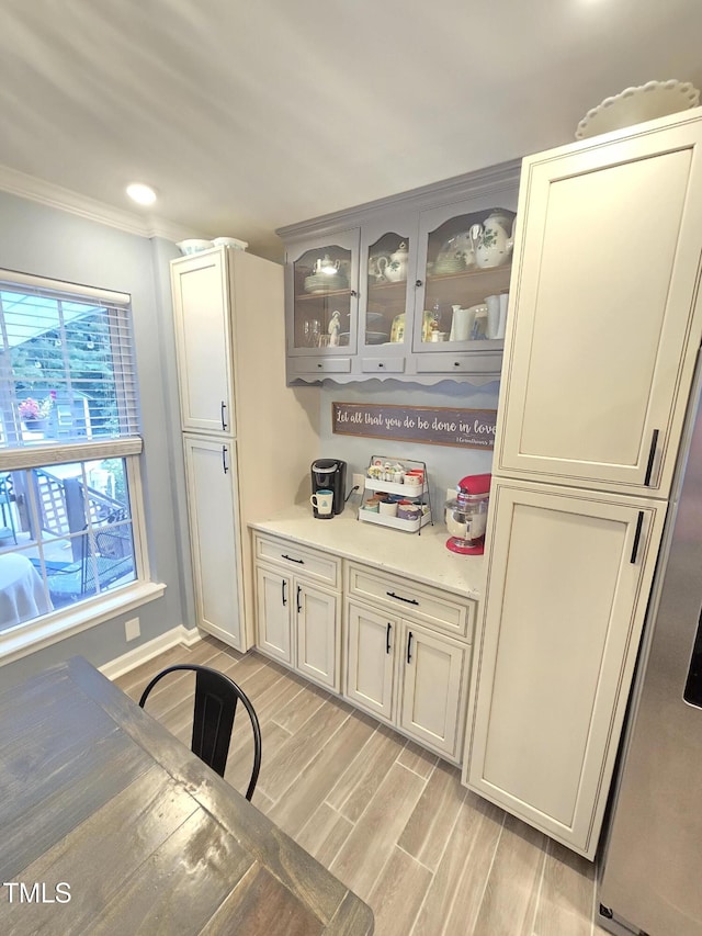 4411 Fairland Ct, Burlington, NC 27215 - kitchen with ornamental molding, light countertops, glass insert cabinets, and light wood finished floors