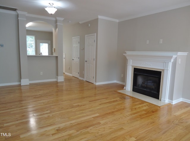 8315 City Loft Ct, Raleigh, NC 27613 - unfurnished living room featuring arched walkways, light wood finished floors, crown molding, and a fireplace with flush hearth