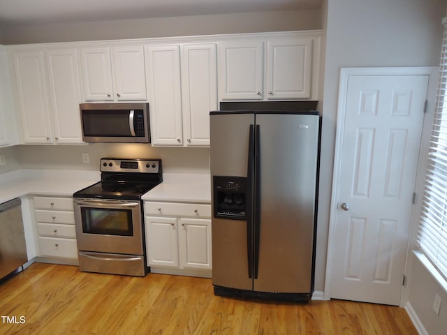 8315 City Loft Ct, Raleigh, NC 27613 - kitchen with appliances with stainless steel finishes, white cabinetry, light wood finished floors, and light countertops