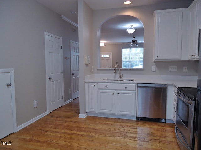 8315 City Loft Ct, Raleigh, NC 27613 - kitchen featuring appliances with stainless steel finishes, arched walkways, white cabinets, light countertops, and recessed lighting