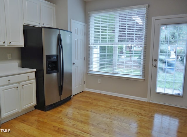 8315 City Loft Ct, Raleigh, NC 27613 - kitchen with stainless steel fridge, light wood-style flooring, white cabinetry, and light countertops