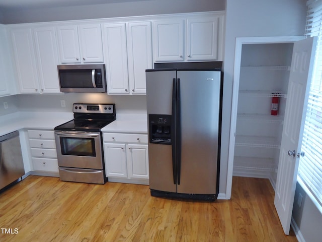 8315 City Loft Ct, Raleigh, NC 27613 - kitchen featuring stainless steel appliances, white cabinetry, light wood-type flooring, and light countertops