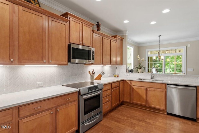2800 Royal Forrest Dr, Raleigh, NC 27614 - kitchen featuring appliances with stainless steel finishes, ornamental molding, wood finished floors, brown cabinetry, and light countertops