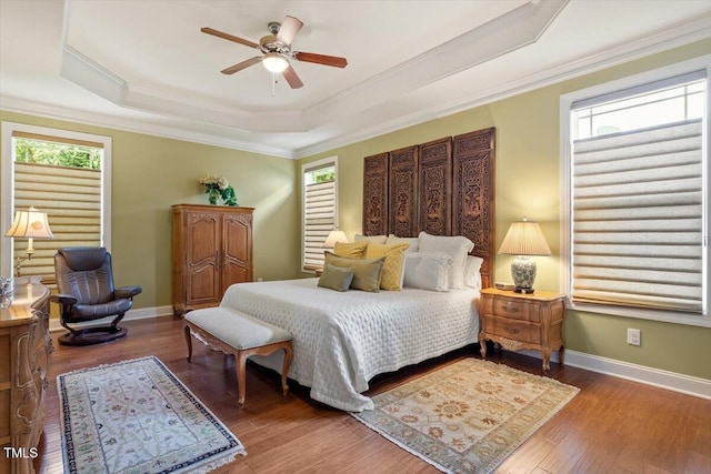 2800 Royal Forrest Dr, Raleigh, NC 27614 - bedroom featuring a raised ceiling, multiple windows, crown molding, wood finished floors, and a ceiling fan