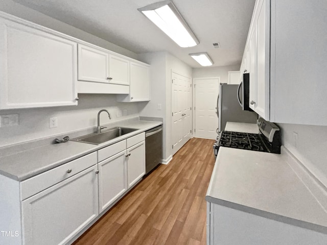 1628 Winnabow Dr, Fayetteville, NC 28304 - kitchen featuring stainless steel appliances, white cabinets, light wood-style flooring, and light countertops