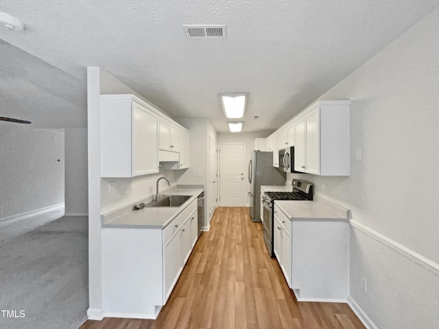 1628 Winnabow Dr, Fayetteville, NC 28304 - kitchen featuring appliances with stainless steel finishes, light countertops, white cabinets, and light wood-type flooring