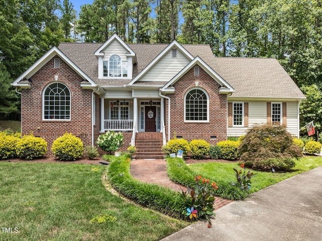 430 Beechwood Trl, Henderson, NC 27536 - view of front of home with a shingled roof, a porch, a front lawn, and brick siding