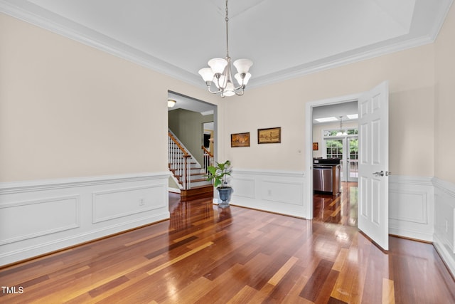 430 Beechwood Trl, Henderson, NC 27536 - dining room featuring wood finished floors, a chandelier, stairway, ornamental molding, and wainscoting