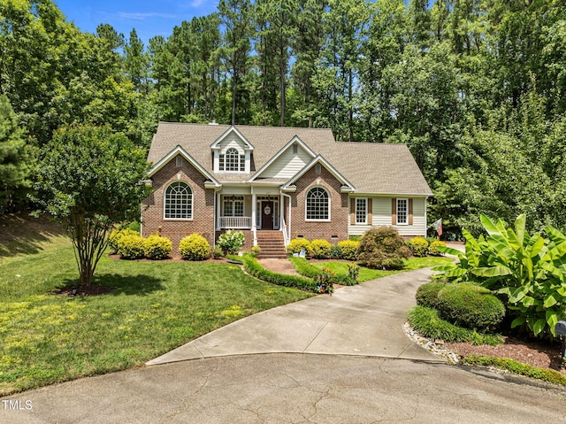 430 Beechwood Trl, Henderson, NC 27536 - view of front of house featuring brick siding, a front lawn, concrete driveway, and a porch