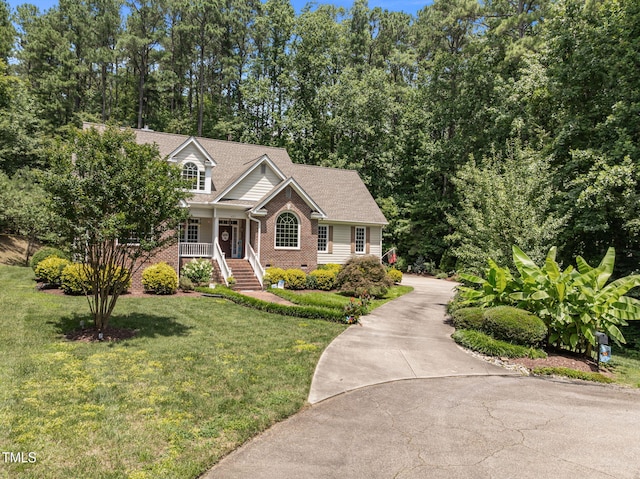 430 Beechwood Trl, Henderson, NC 27536 - view of front of home with covered porch, a front lawn, concrete driveway, brick siding, and crawl space