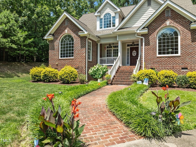430 Beechwood Trl, Henderson, NC 27536 - view of front facade featuring a porch, brick siding, a shingled roof, a front yard, and stairs