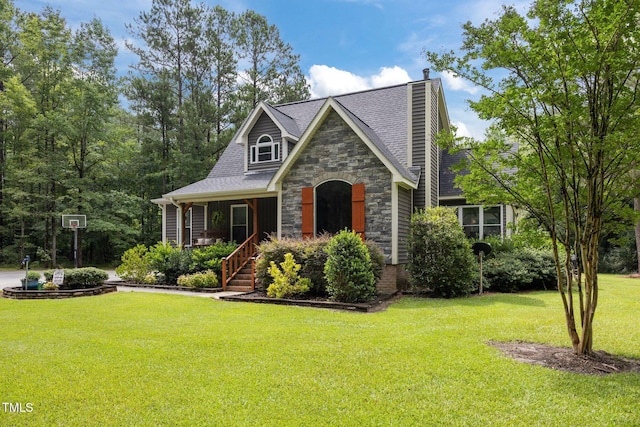 1128 Old Stage Rd S, Erwin, NC 28339 - view of front facade featuring stone siding, a front lawn, a chimney, covered porch, and roof with shingles
