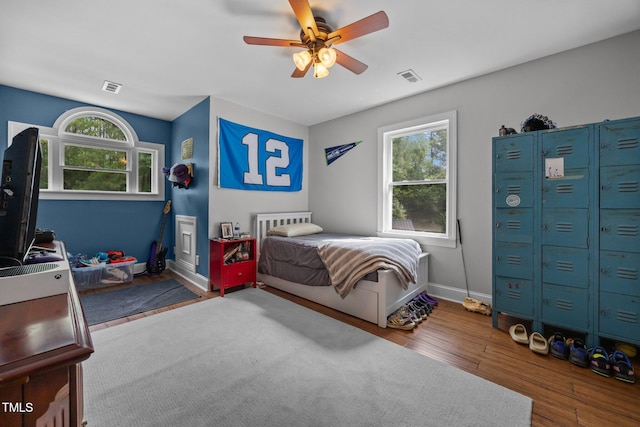 1128 Old Stage Rd S, Erwin, NC 28339 - bedroom with multiple windows, wood finished floors, and ceiling fan