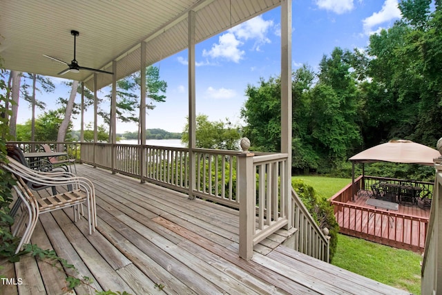 4904 Pebble Beach Cir N, Wilson, NC 27896 - deck with a water view, outdoor dining space, a ceiling fan, and view of scattered trees