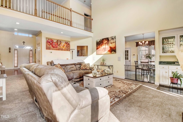 4904 Pebble Beach Cir N, Wilson, NC 27896 - carpeted living area featuring a high ceiling, a chandelier, and crown molding