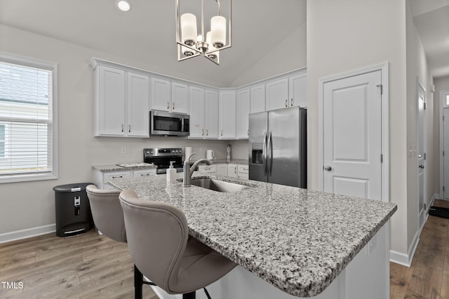 312 E Yukon St, Kenly, NC 27542 - kitchen with appliances with stainless steel finishes, a chandelier, white cabinets, light wood-style flooring, and vaulted ceiling