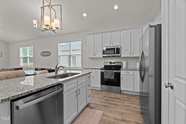 312 E Yukon St, Kenly, NC 27542 - kitchen with appliances with stainless steel finishes, open floor plan, white cabinets, light wood-style flooring, and a chandelier
