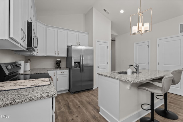 312 E Yukon St, Kenly, NC 27542 - kitchen with stainless steel appliances, white cabinets, dark wood finished floors, light stone counters, and pendant lighting
