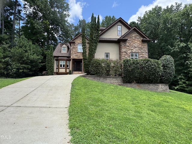 2305 Berteau Dr, Wake Forest, NC 27587 - craftsman-style home with driveway, stone siding, a front lawn, and a garage