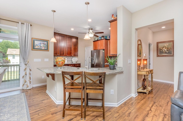 1205 Barnford Mill Rd, Wake Forest, NC 27587 - kitchen featuring stainless steel fridge, light wood-style flooring, a peninsula, backsplash, and recessed lighting