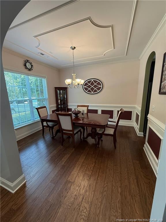 5724 Avera Ln, Holly Springs, NC 27540 - dining space with arched walkways, dark wood-style floors, a wainscoted wall, crown molding, and a chandelier