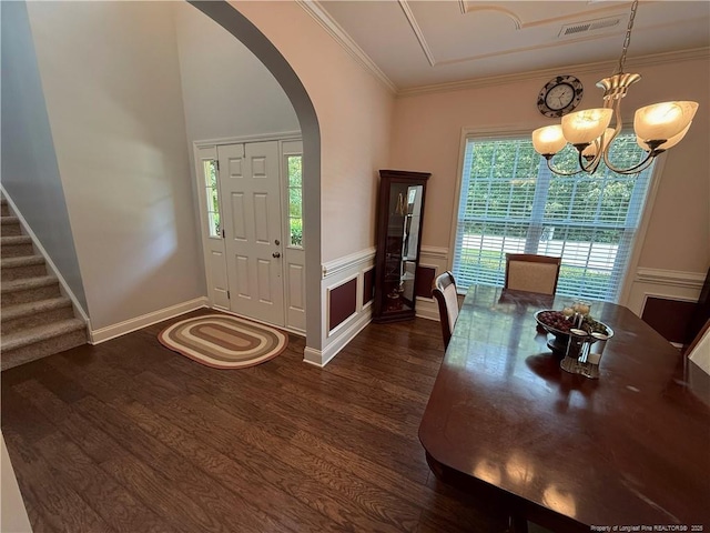 5724 Avera Ln, Holly Springs, NC 27540 - foyer with arched walkways, dark wood-style flooring, a chandelier, wainscoting, and crown molding