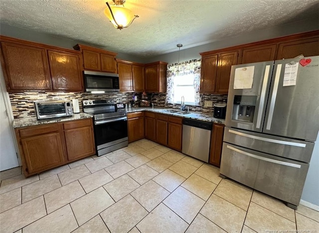 7453 Avila Dr, Fayetteville, NC 28314 - kitchen with stainless steel appliances, backsplash, a textured ceiling, and brown cabinetry