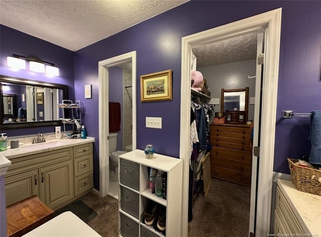 7453 Avila Dr, Fayetteville, NC 28314 - bathroom with a textured ceiling, vanity, and a spacious closet