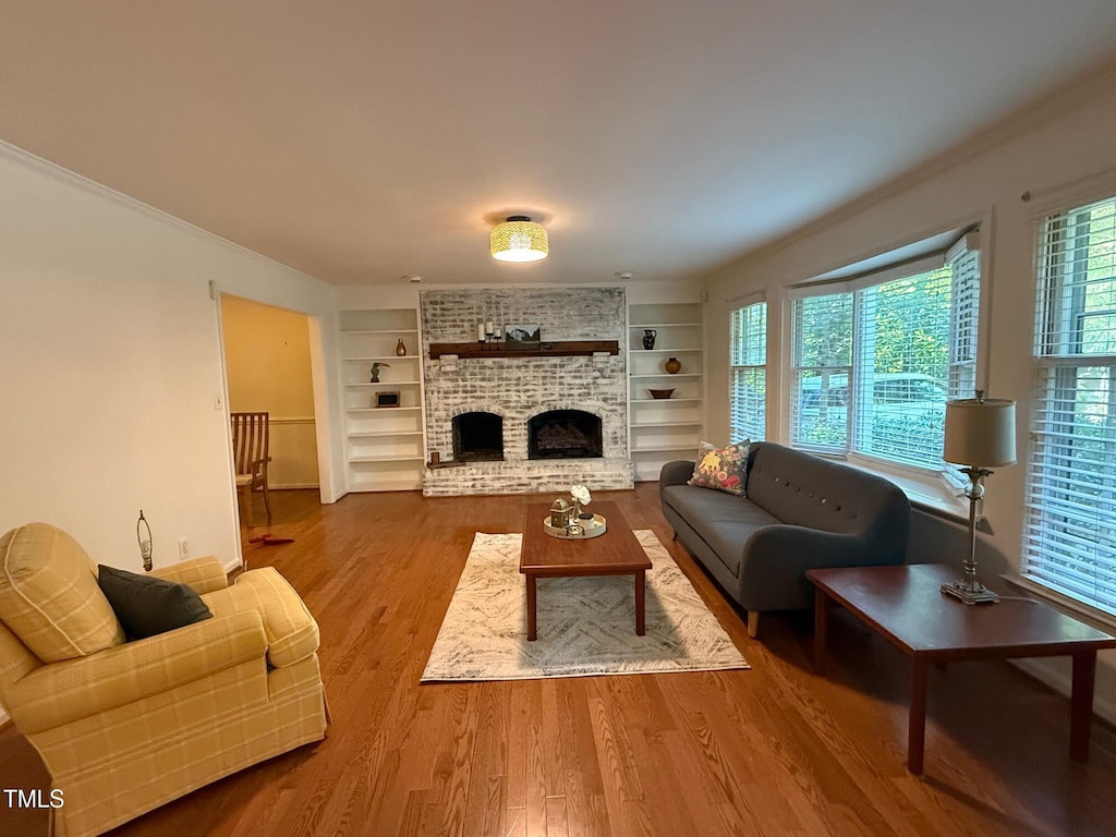 1221 Moultrie Ct, Raleigh, NC 27615 - living area featuring wood finished floors, built in features, and a fireplace