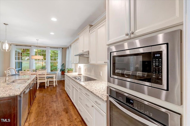 3650 Brooks Bnd, Franklinton, NC 27525 - kitchen featuring stainless steel appliances, white cabinets, wood finished floors, under cabinet range hood, and light stone countertops