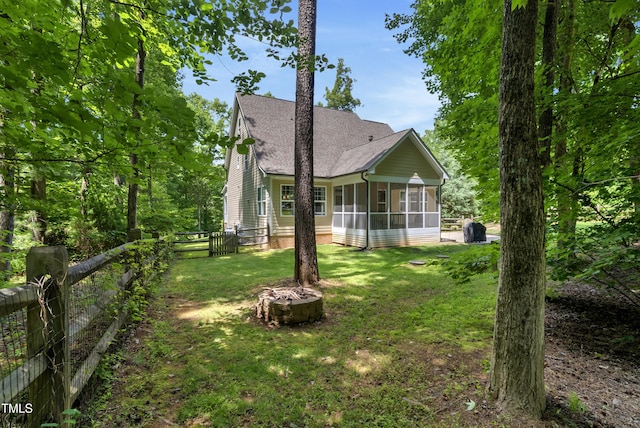 3650 Brooks Bnd, Franklinton, NC 27525 - rear view of property featuring a sunroom, a fire pit, a shingled roof, and a fenced backyard