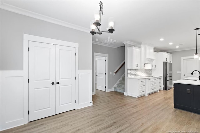 232 Captain Hbr, Sanford, NC 27332 - kitchen featuring freestanding refrigerator, ornamental molding, light countertops, a chandelier, and white cabinetry