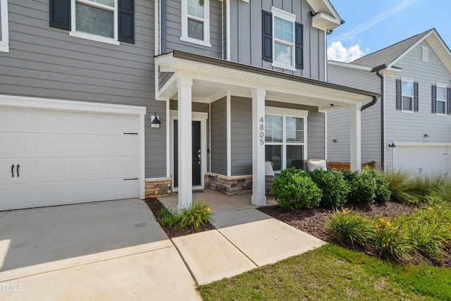 4805 Ozark St, Fuquay Varina, NC 27526 - view of front facade with a garage, board and batten siding, covered porch, concrete driveway, and stone siding