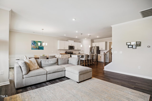 4805 Ozark St, Fuquay Varina, NC 27526 - living room with dark wood finished floors, a chandelier, crown molding, recessed lighting, and stairway