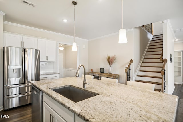4805 Ozark St, Fuquay Varina, NC 27526 - kitchen featuring stainless steel appliances, crown molding, dark wood-type flooring, hanging light fixtures, and white cabinetry