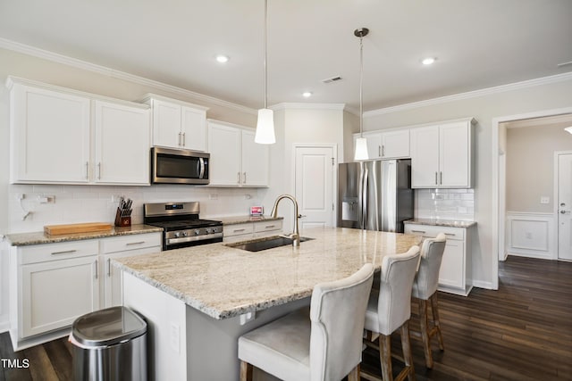 4805 Ozark St, Fuquay Varina, NC 27526 - kitchen with stainless steel appliances, dark wood-style flooring, white cabinets, tasteful backsplash, and a center island with sink