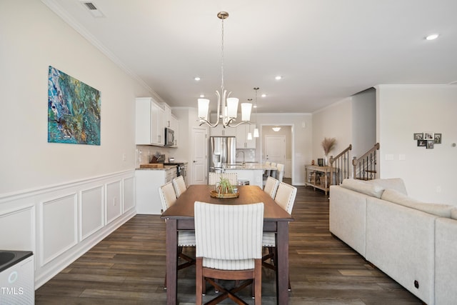 4805 Ozark St, Fuquay Varina, NC 27526 - dining area featuring a chandelier, ornamental molding, recessed lighting, dark wood finished floors, and stairs